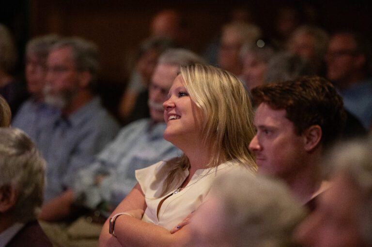 young woman looks like she's have a great time at a symphony concert