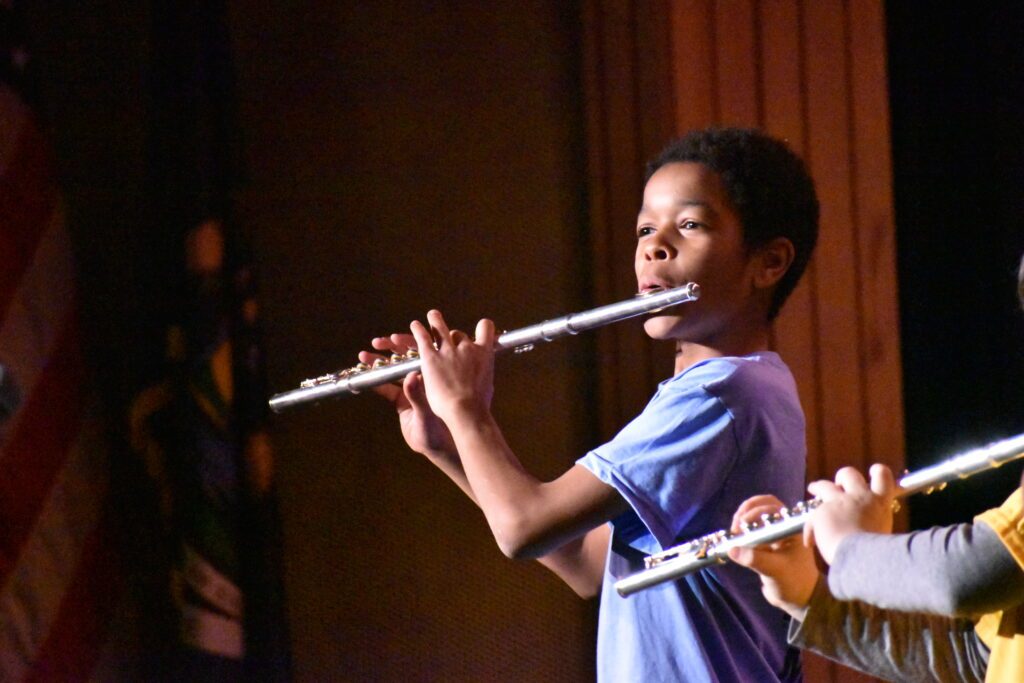 young boy plays the flute