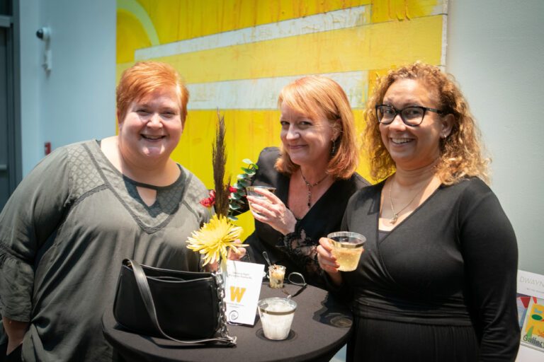 three ladies cheers in the concert hall lobby
