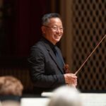 kso concertmaster jun-ching lin smiles while holding violin