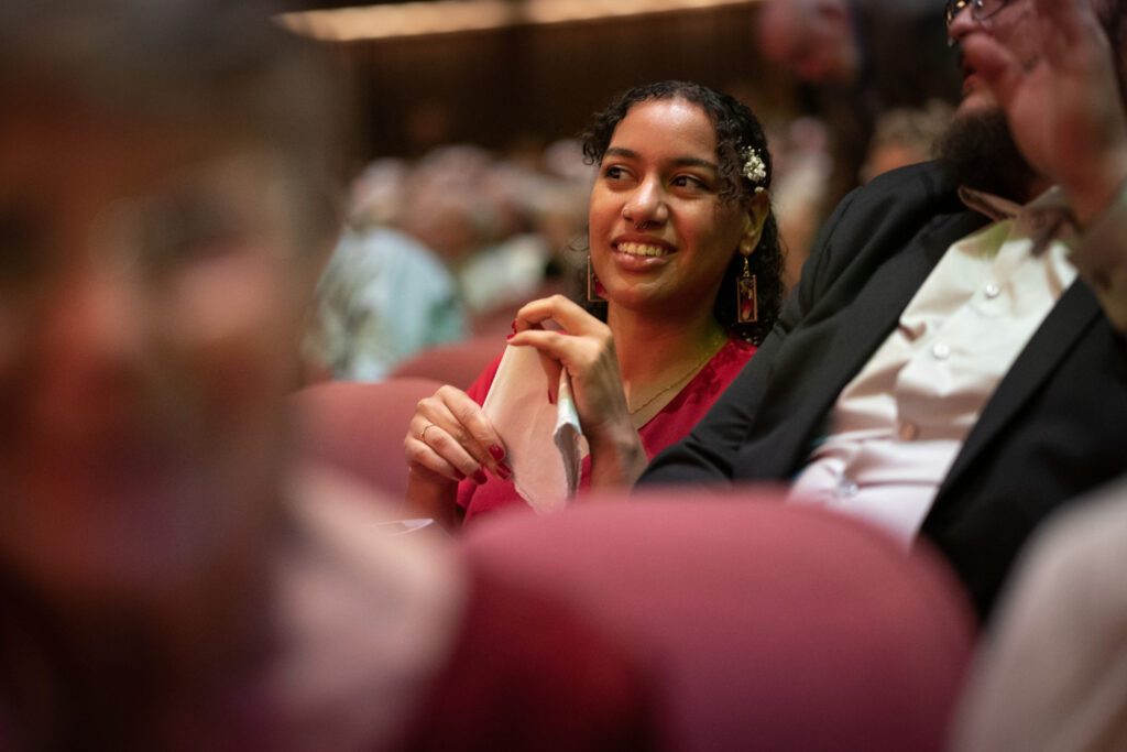 girl talks to friend in concert hall