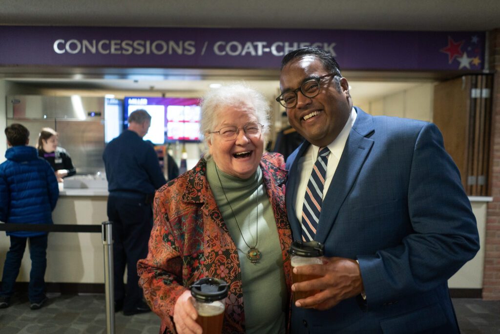 two people laugh with each other in the concert hall lobby