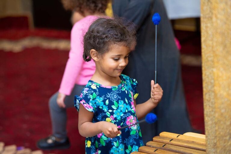 young girl plays percussion instrument