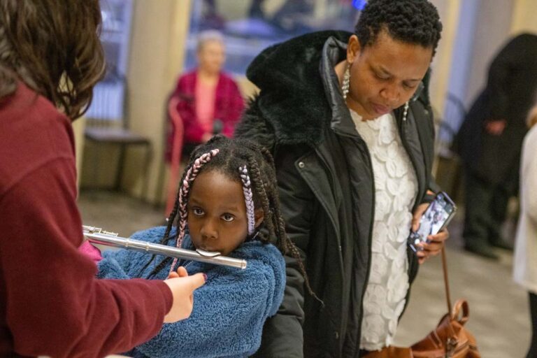 young girl learns to play the flute