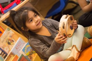 young preschool girl plays tambourine during marvelous music session