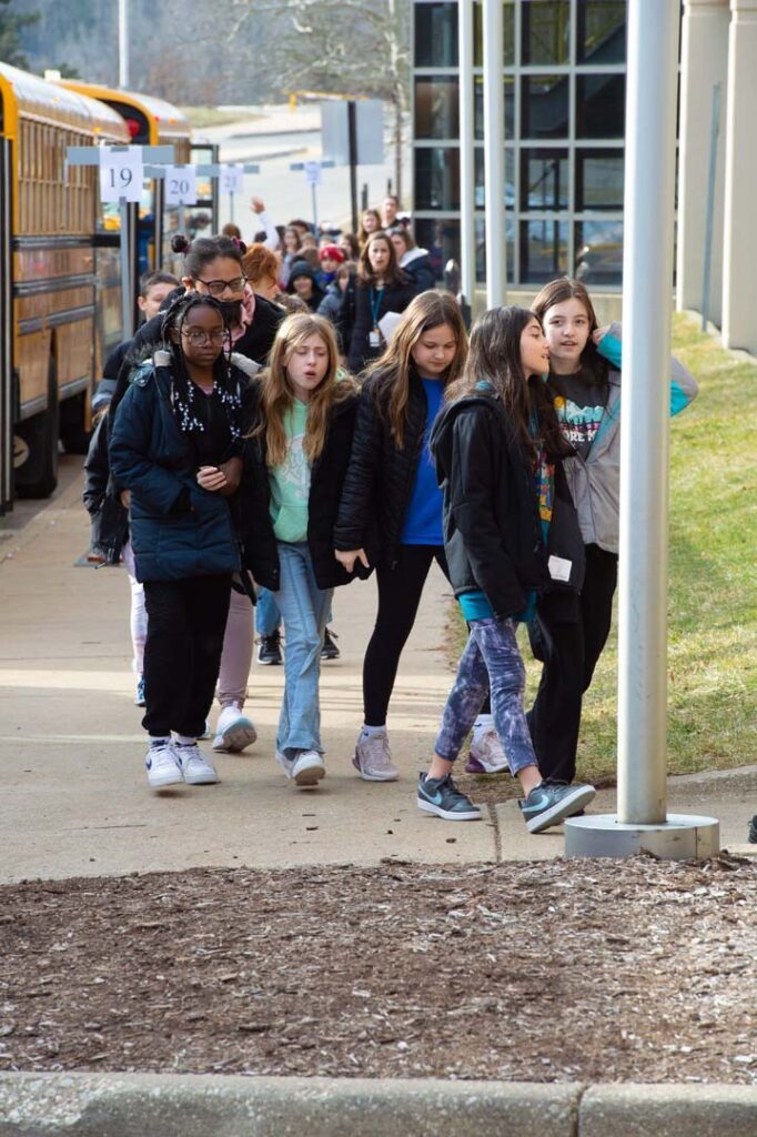 group of students get off bus at concert hall
