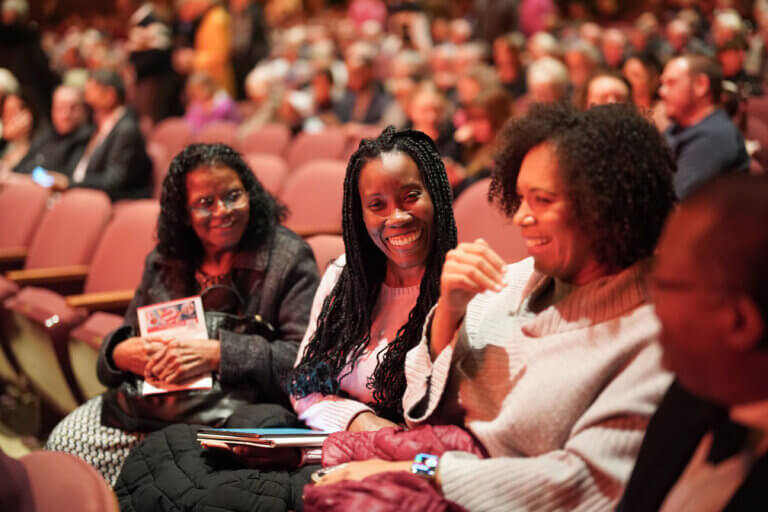 women laugh in the concert hall